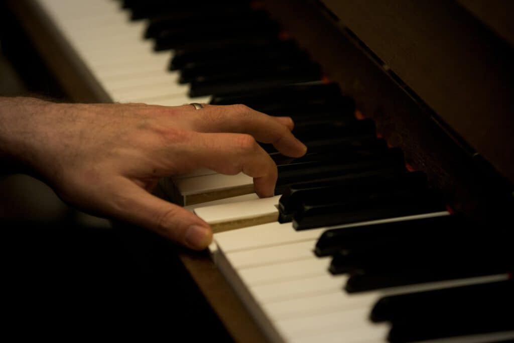 a man is playing on the piano with his left hand